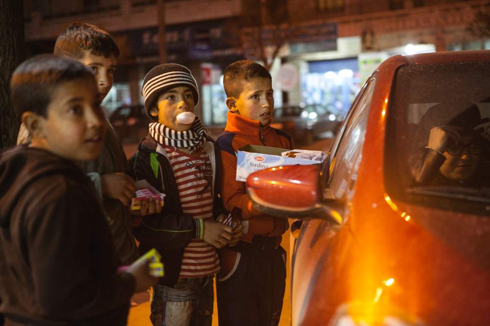 レバノンのベッカー高原に住む子どもたちは、夜の9時に路上でお菓子を売っています。8歳のマームード君（しま模様のシャツ）は、「この方法では、ほんの少しのお金しか稼げないんだ。でも、お互いに助け合って生活しているよ」と、話します。