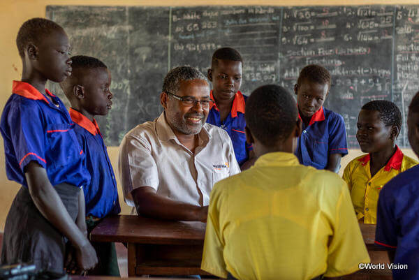 南スーダンの小学校に通う子どもたちとワールド・ビジョンのスタッフ