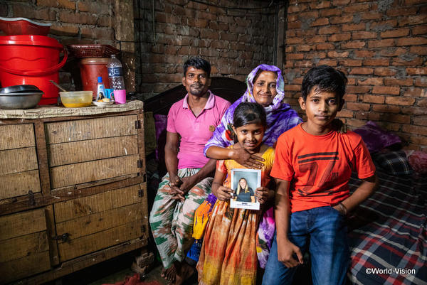 チャイルド・スポンサーの写真を持つバングラデシュの少女とその家族