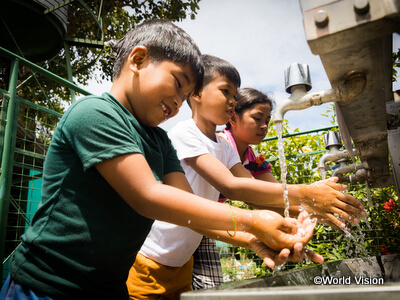 ワールド・ビジョンの取り組みによって、学校できれいな水を利用できるようになったことを喜ぶフィリピンの子どもたち