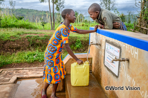 支援によりできた水道で、浄化された水を汲むルワンダの子どもたち