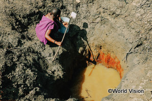 タンザニアの干ばつ地域で生活に使う水を汲む女性