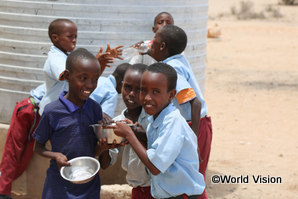 支援により学校に設置された浄水タンクから水を飲むケニアの子どもたち
