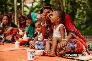 支援により提供された食事を食べ栄養について学ぶバングラディシュの親子