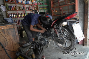 バイクの修理工場で日雇い労働をするバングラディシュの子ども