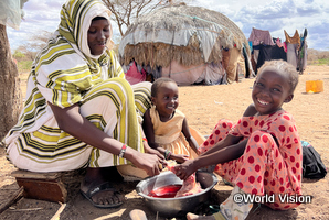 干ばつによる食糧不足のケニア地域で、支援を受ける親子