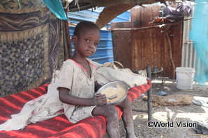 一日に唯一の食事をとる南スーダンの子ども