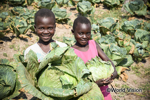 農業技術の支援により育てた野菜を持つコンゴ民主共和国の子どもたち