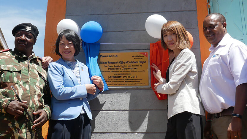 学校に寄贈されたシステムの記念プレートの除幕をする福田氏（中央左）とWVJ事務局長 木内（中央右）