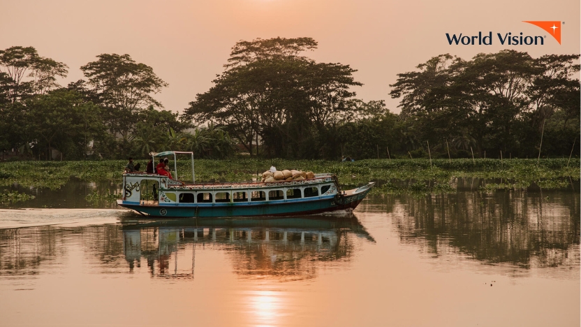夕焼けの中水辺を走らせるボート（バングラデシュ）