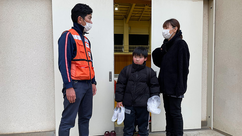 お迎えにいらした保護者の方と話すWVJスタッフ（3月7日撮影）