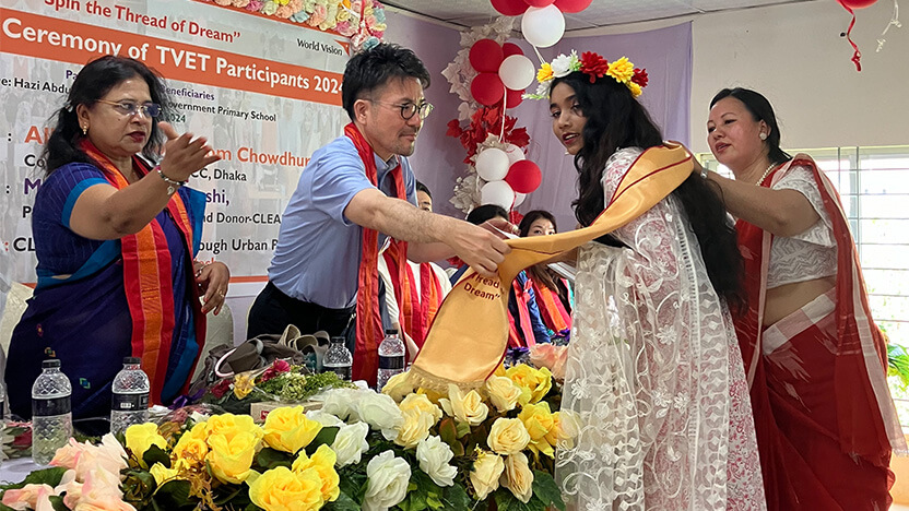 花冠とスカーフを受け取る修了生