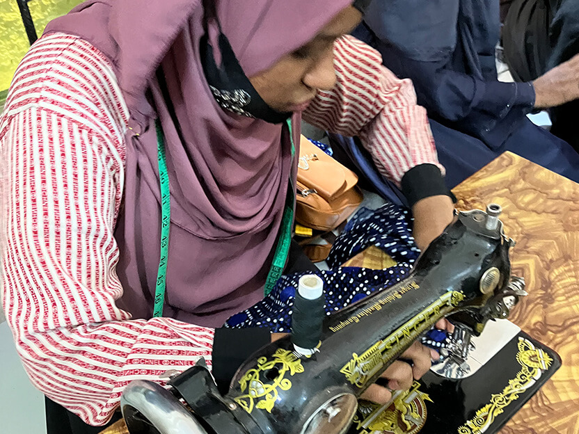 縫製訓練中にベビー服の練習をする様子