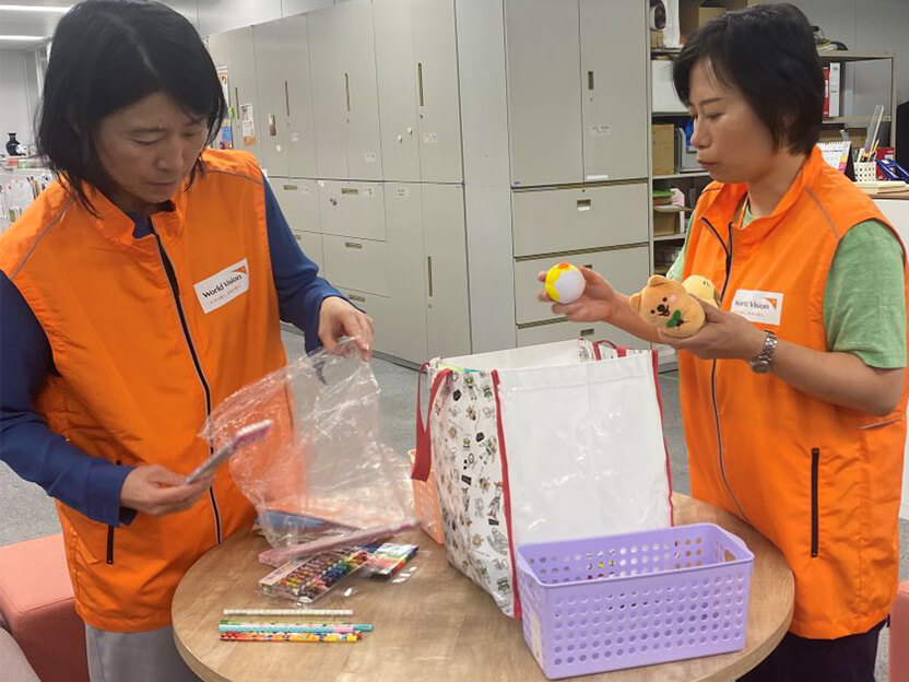 石川県に持参する文房具等を準備するWVJ高橋スタッフ（右）於：WVJ事務所、9月24日夜