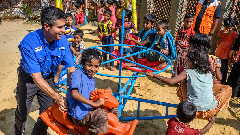 子どもたちと交流するワールド・ビジョンのスタッフ。政府や国際NGO、NPO法人などにより貧困をなくすため、積極的な活動が行われている