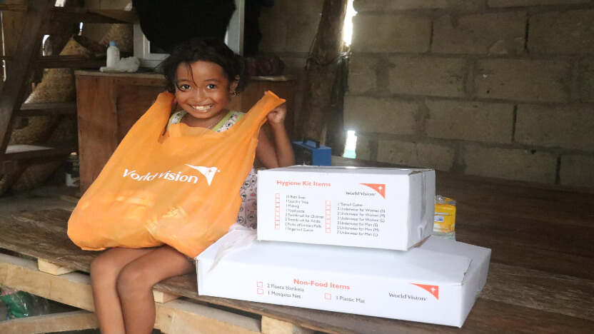 ワールド・ビジョンの支援物資を手にするフィリピンの女の子
