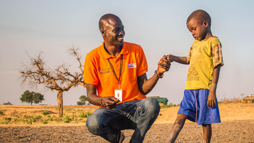 南スーダン難民の少年とワールド・ビジョンのスタッフ