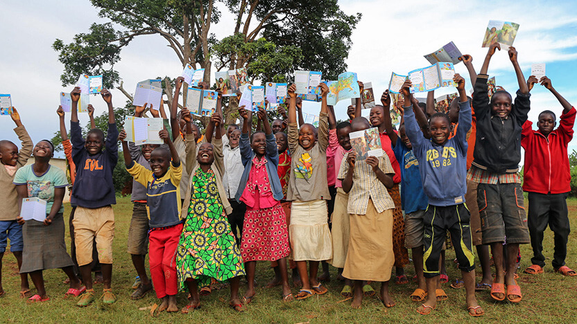 チャイルド・スポンサーからのメッセージカードを高らかに掲げるブルンジの子どもたち