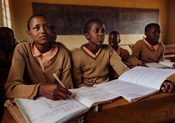 教室で机に向かい学ぶ子どもたち。ワールド・ビジョンの地域開発プログラムが教育環境改善を支援している様子。
