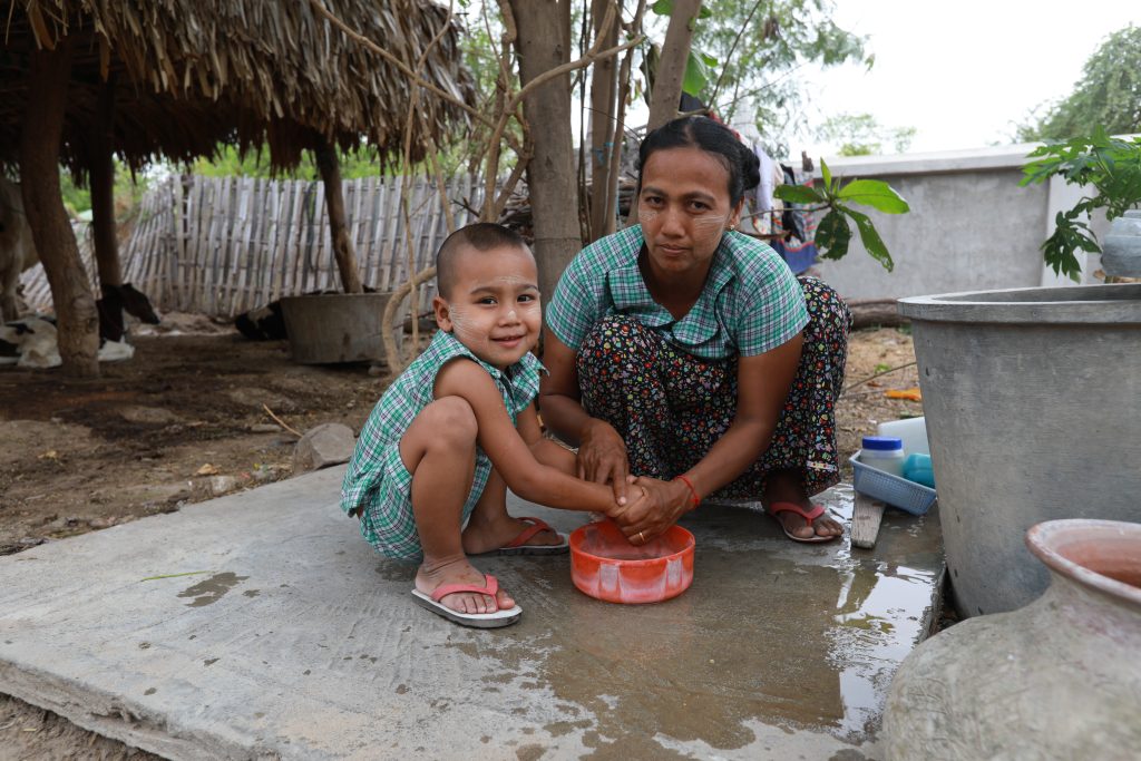 ミャンマーの被災地で手を洗う子どもとその母親