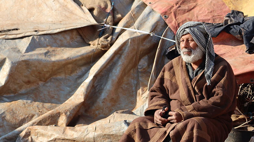 自分のテントの前に座る男性