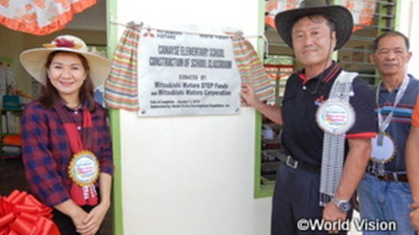 支援を記念したプレートを除幕するMMPC丸山副社長と教育省学校部門監督のマリザ氏（左）