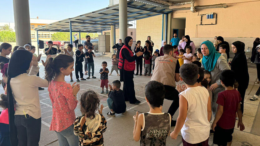 避難所で、子どもたちに心理社会的支援や楽しくすごせる機会を提供するワールド・ビジョン・スタッフ