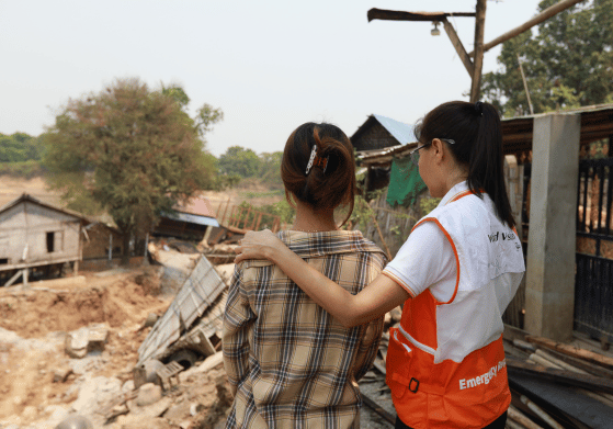 自然災害の爪痕が残る地域で、支援スタッフが被災者に寄り添いながら健康支援を実施している様子。