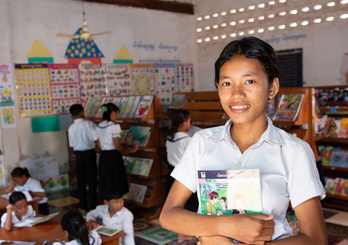 図書室で学ぶ子どもたちと、本を手に希望を語る少女。教育支援の大切さを伝える場面。