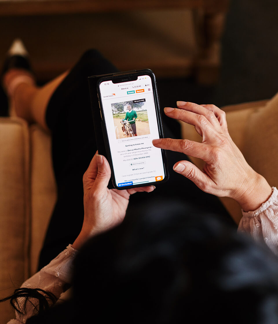 チャイルド・スポンサーがスマートフォンで支援している子どもの近況や手紙を確認し、つながりを深めている様子。