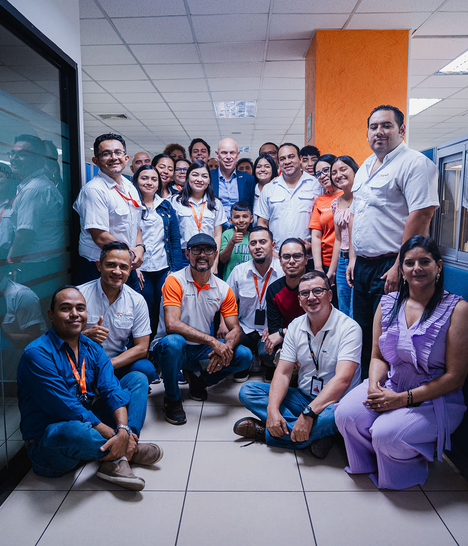 子ども支援や教育支援に取り組むワールド・ビジョンのスタッフが事務所で笑顔を見せる場面。