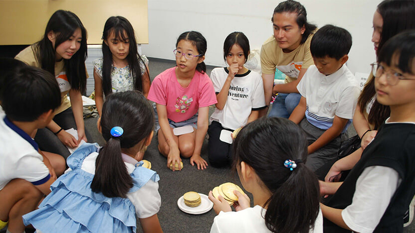 「世界がもし100人の村だったら」ワークショップで富の分配をビスケットで表し話し合いました