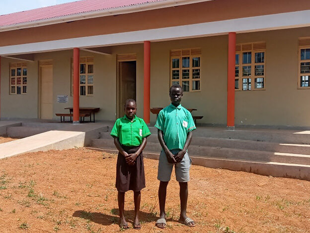 新しい校舎の前に立つ生徒