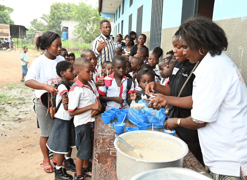 学校でお粥を受け取る子どもたち