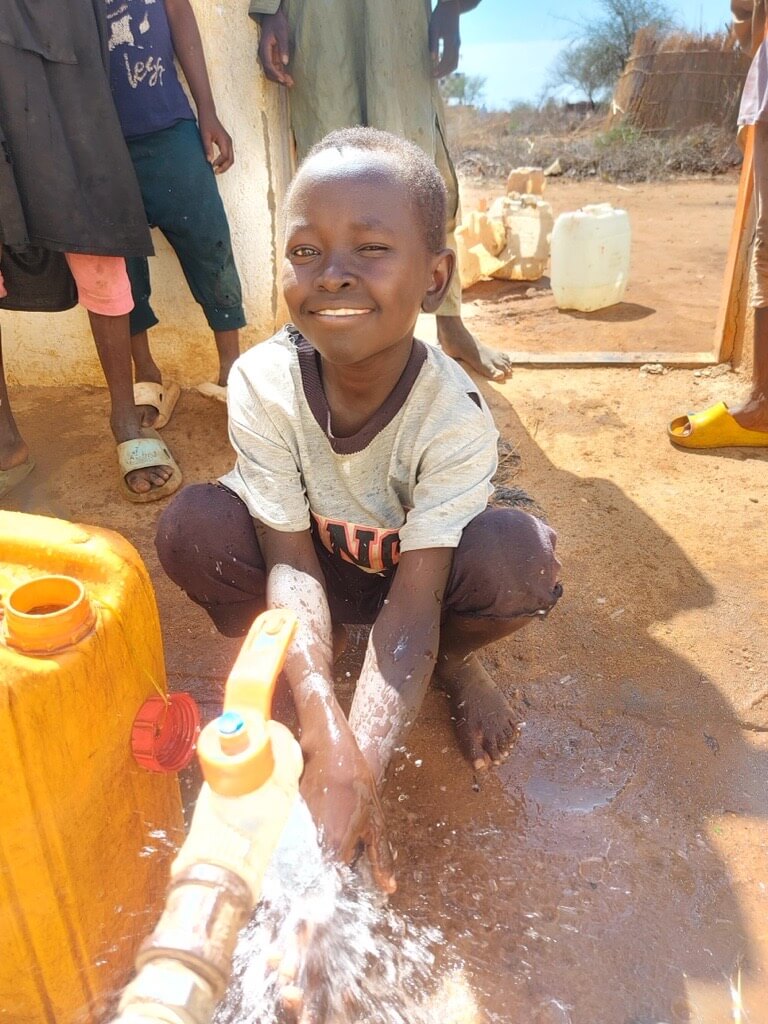 修繕した給水所を使う子ども