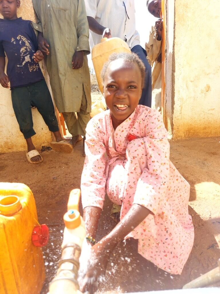 修繕した給水所を使う子ども