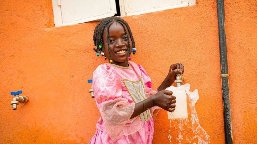 ワールド・ビジョンの支援により設置された給水設備から水をくむ少女（ガーナ）