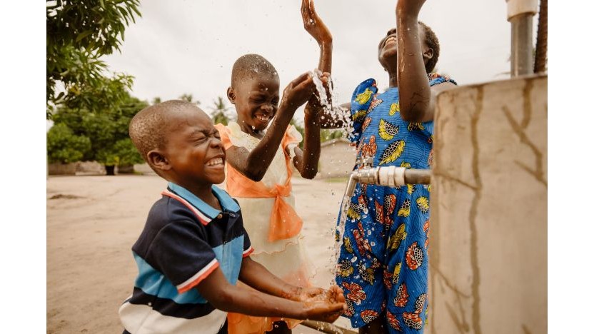 ワールド・ビジョンの支援で整備された給水設備と子どもたち（ガーナ）