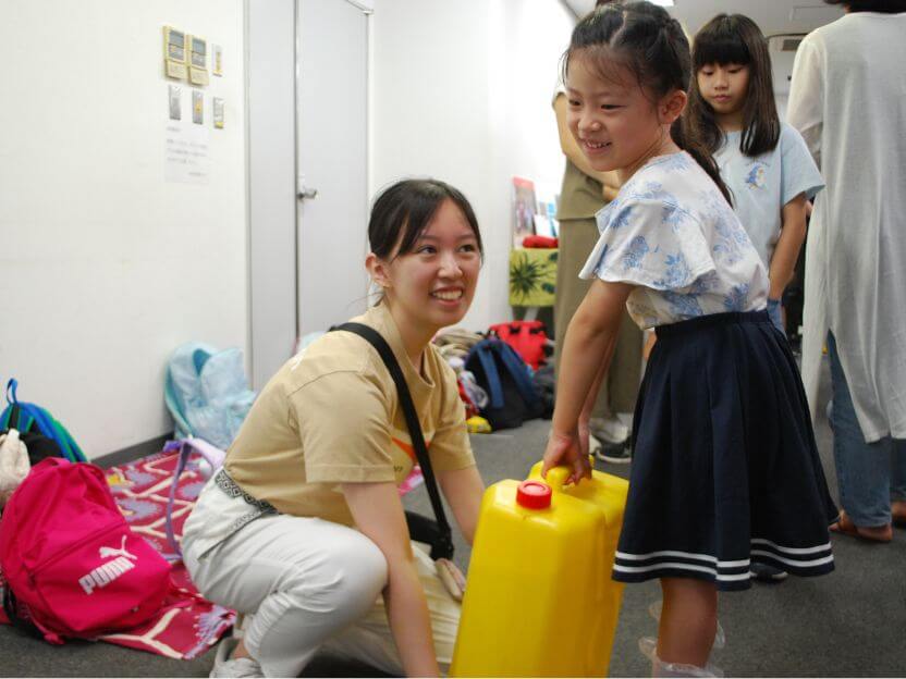 「重くて歩けないよー」と驚きの声があがる「水汲み体験」