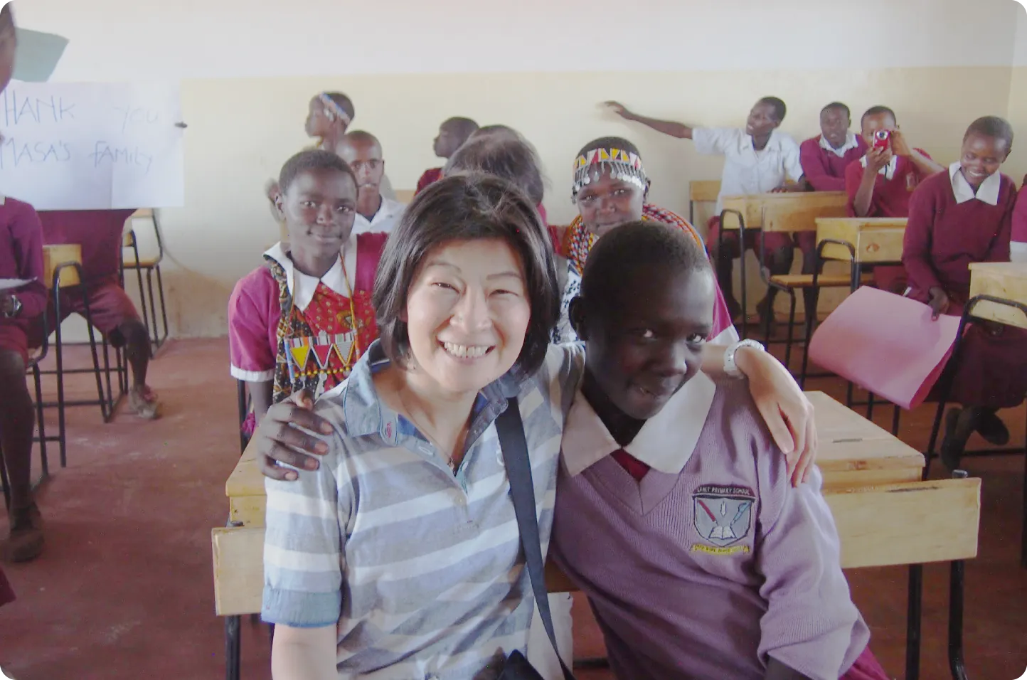 山崎さまのご家族（左）と、ご遺贈により校舎を建設した学校の女子児童（右）