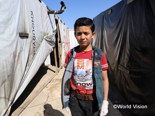 難民キャンプで暮らすシリア難民の少年。狭い場所に簡素なテント小屋がぎっしり並び、生活環境は良くありません