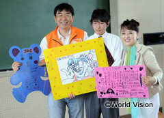 ①台湾の子どもたちからのメッセージを手渡すジュディさん。左は、ハンク・デュウWV台湾事務局長