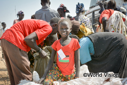 届けられた食糧に笑顔を浮かべる、南スーダンの女の子（2014年）