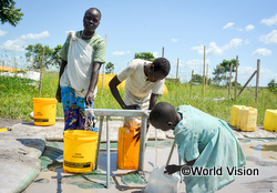 設置された水道で清潔な水を汲む子どもたち