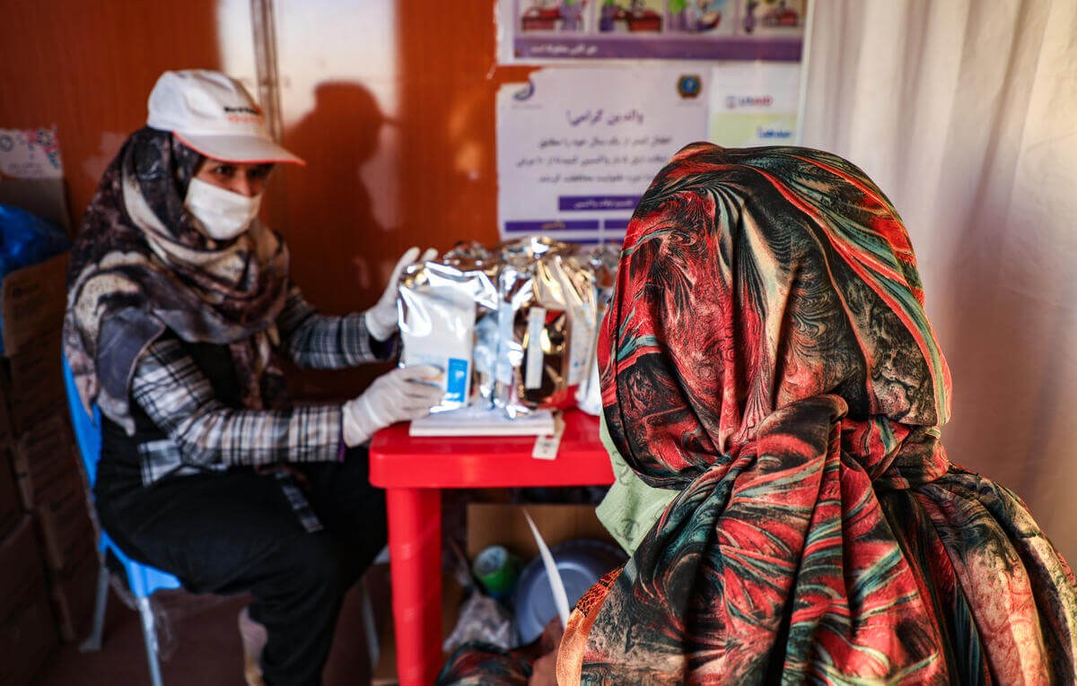 ワールド・ビジョンの移動診療チームから栄養補助食パッケージを受け取る女性