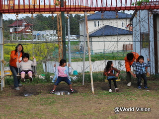 CFSでブランコで遊ぶ子どもたちとWVJスタッフ（2011年）