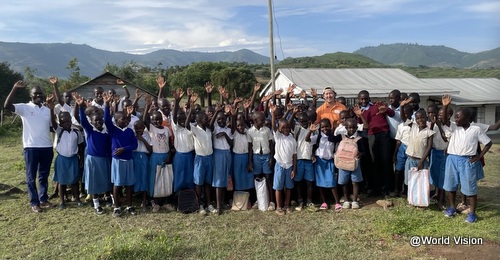 ケニアの事業地の小学校の子どもたちとWVJ遠藤スタッフ（後列オレンジ色のシャツ）