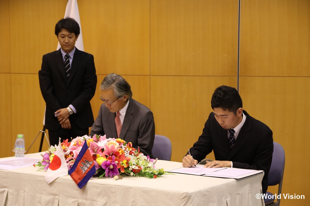 在カンボジア日本国大使館での署名式 堀之内大使（左）と松岡スタッフ（右）